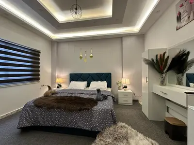a bedroom with a large bed with a blue headboard at Jerash City View in Jerash