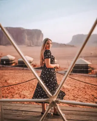 a woman walking on a bridge in the desert at LARA lUXURY CAMP in Wadi Rum