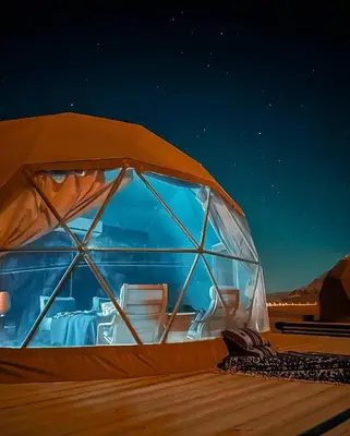 an igloo with chairs inside of it at night at LARA lUXURY CAMP in Wadi Rum