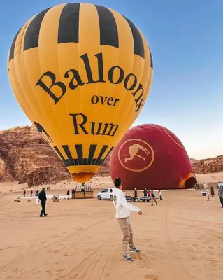 a group of people flying hot air balloons in the desert at LARA lUXURY CAMP in Wadi Rum