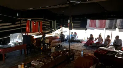 a group of people sitting inside of a tent at Wadi Rum Majestic Camp in Wadi Rum
