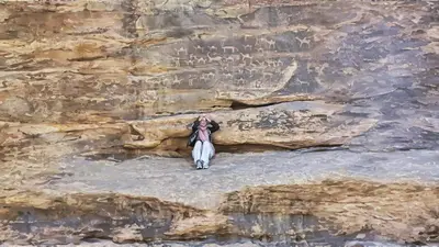 a person standing on top of a rocky cliff at Wadi Rum Majestic Camp in Wadi Rum
