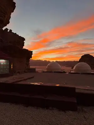 two domes in the desert with a sunset in the background at Red Twilight Camp in Disah