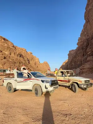 two jeeps parked in the desert next to a truck at Red Twilight Camp in Disah