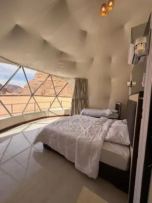 a bedroom with a bed with a view of the desert at Red Twilight Camp in Disah