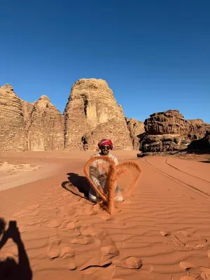 a man sitting in the desert with a wreath at wadirumtours&camp in Wadi Rum