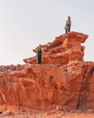 two people are standing on top of a rock at Wadi Rum Gulf camp in Aqaba