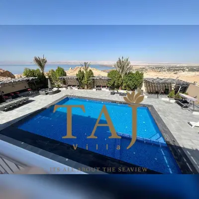 a view of a pool at a resort with the taa logo at Taj Villa 1 deadsea - Entire Villa with sea view in Sowayma