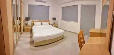 a bedroom with a white bed and two windows at Byblos Deluxe in Aqaba