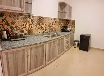 a kitchen with wooden cabinets and a sink at Byblos Deluxe in Aqaba