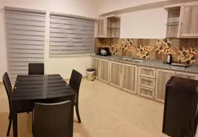 a kitchen with a table and chairs in a kitchen at Byblos Deluxe in Aqaba