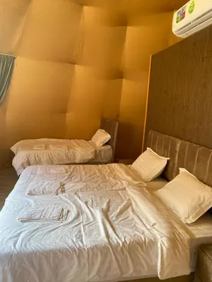 a room with two beds in a room at Bedouin Secret Camp in Wadi Rum