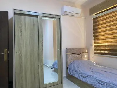 a bedroom with a glass door leading to a bed at Moon Apartments in Jerash