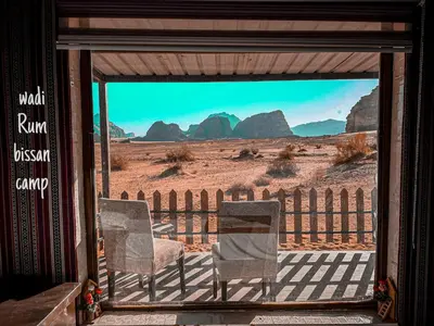 two chairs on a porch with a view of the desert at wadi Rum bissan camp in Wadi Rum