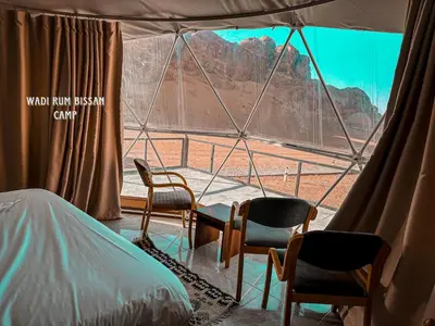 a room with chairs and a view of a mountain at wadi Rum bissan camp in Wadi Rum