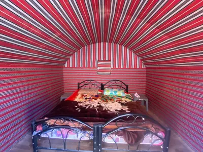 a red and white room with a bed in it at Desert Gate Camp in Wadi Rum