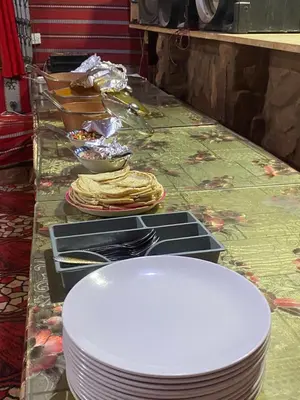 a table with plates and bowls of food on it at Desert Gate Camp in Wadi Rum