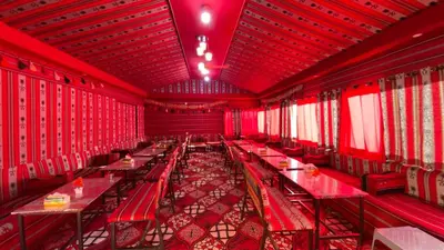 a red room with red tables and chairs at Desert Gate Camp in Wadi Rum