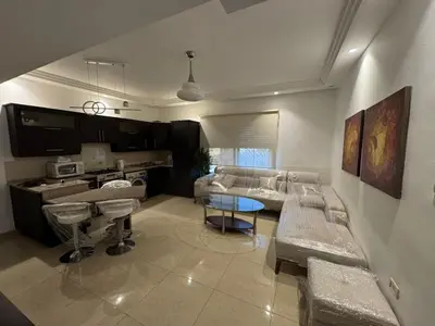 a living room with a couch and a table at Furnished apartment for rent In Abdoun شقة مفروشة للايجار في عبدون in Amman