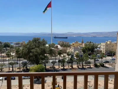 a view from the balcony of a resort with a flag at Castle beach hotel in Aqaba