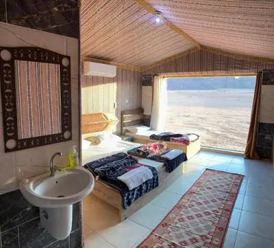 a bathroom with two beds and a sink in it at camp scylla Wadi Rum in Wadi Rum