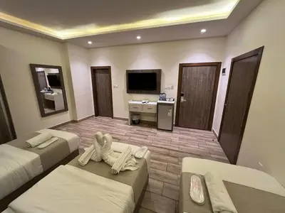 a hotel room with two beds and a tv at Sky Hotel in Aqaba