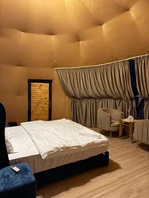 a bedroom with a bed and a chair in it at Wadi Rum alsultan Camp in Wadi Rum